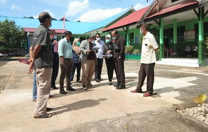 Muhammad Toufan Achmad (tengah) saat menunjukkan batas tanah kliennya di lokasi SDN 2 Wajo. Foto: dok pribadi