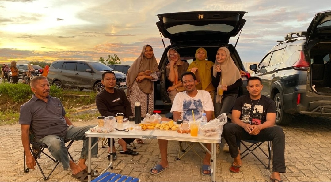 Syaiful bersama keluarga saat menikmati senja di kawasan parkir Masjid Al Alam Kendari. Foto: Yayang